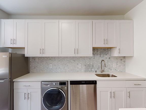 Kitchen with cabinets, refrigerator, sink, washer, and dishwasher