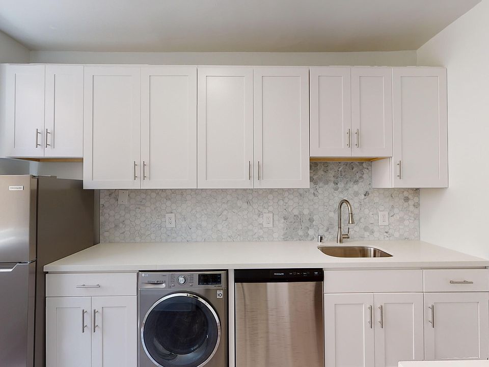 Kitchen with cabinets, refrigerator, sink, washer, and dishwasher