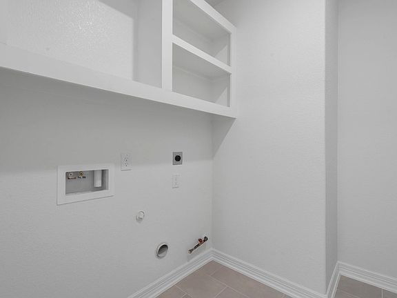 The utility room is a convenient laundry space with room for storage and organization.