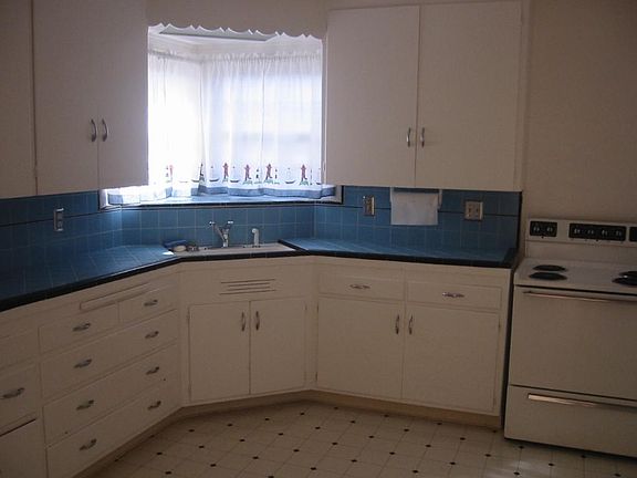 Large county style kitchen with lots of cabinets , stove and refrigerator