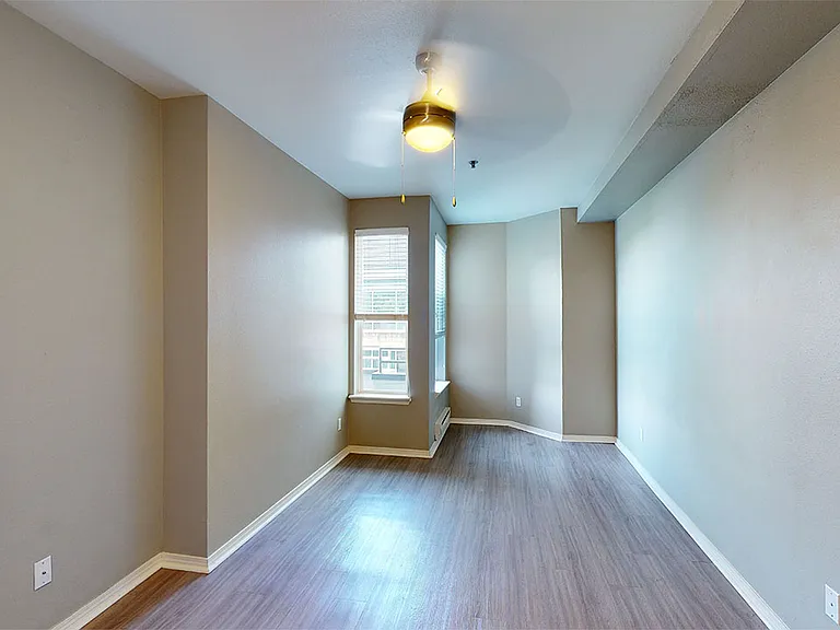 Spacious apartment bedroom with wood-style flooring.