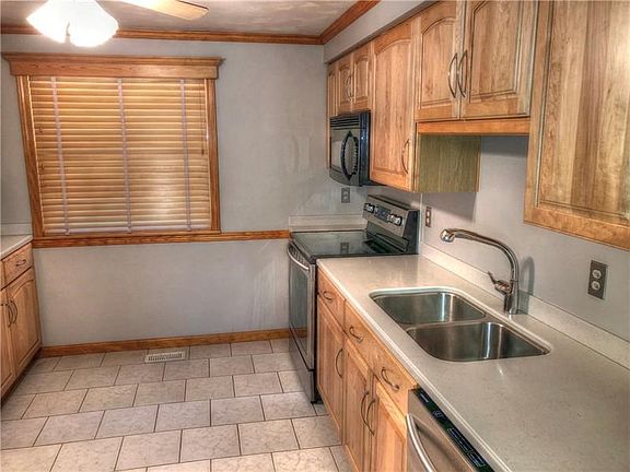 Large window in kitchen is framed with detailed cornices.  Loads of counter space and cabinets galore.
