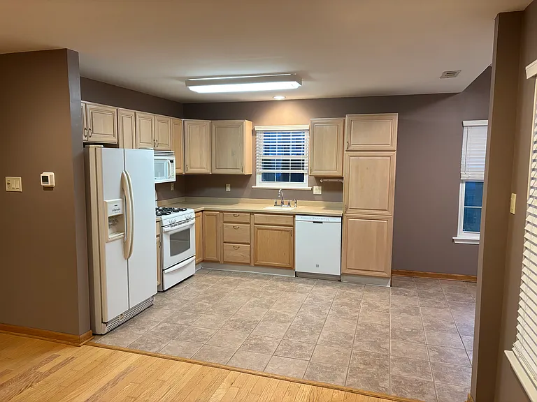 Kitchen, wooded cabinets, windows.