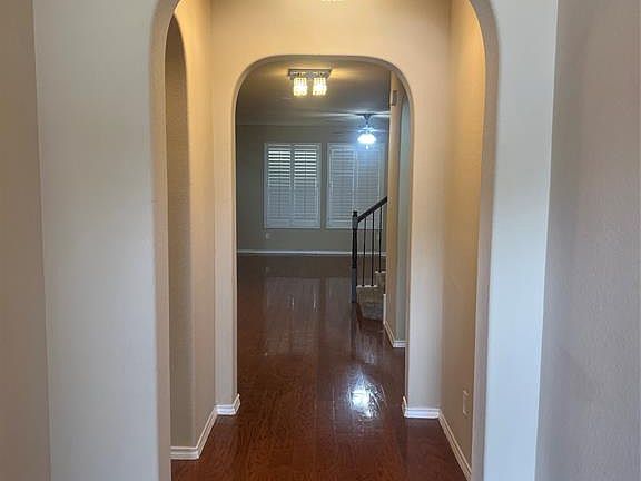 Hallway featuring dark wood-style flooring and stairway
