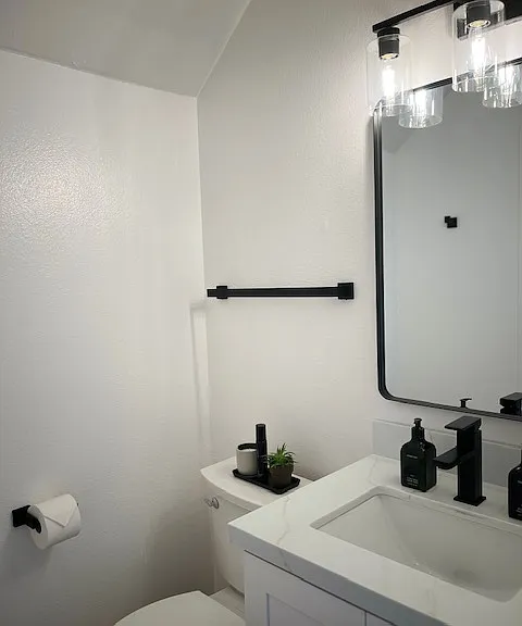 Newly renovated 1/2 bath on main level with quartz countertops, custom cabinetry and Moen faucet