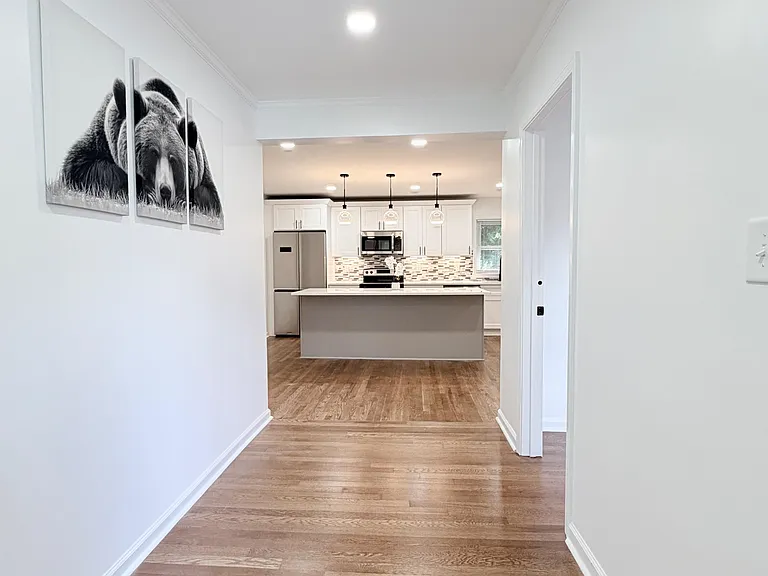 Open kitchen features a large island, stainless-steel appliances, and ample cabinet storage with recessed lighting.