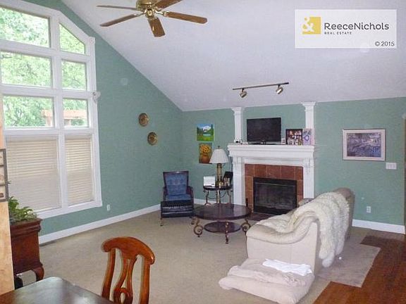 Vaulted Great Room with wall of windows & gas start fireplace.