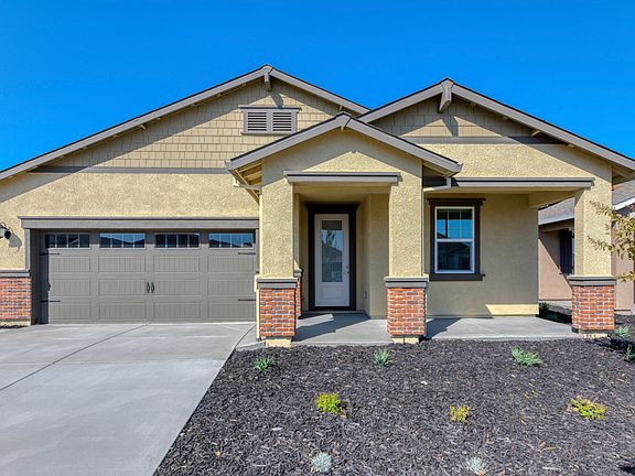 Massive covered porch, 3 4 lite door, and brick detailing add to elegance of the home