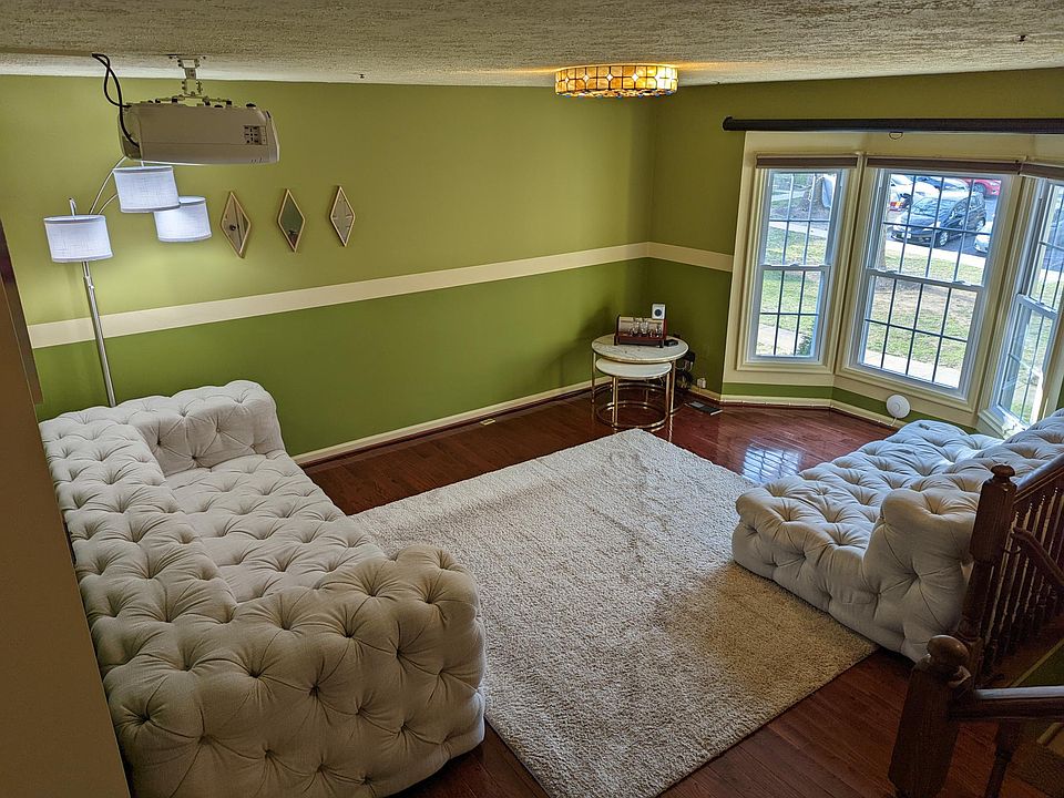 The living room with HD projector and panoramic bay window. Furniture/carpet not included.