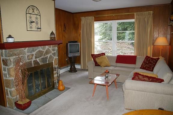 Warm Family Room with wood-burning fireplace and powder room