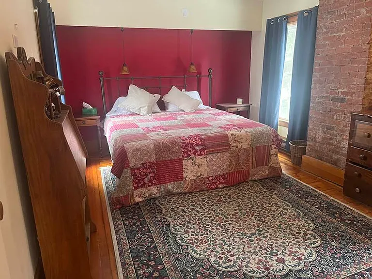 One of the two bedroom suites - windows on each side of bed offer a lovely breeze; brick sets it off beautifully. King size bed.