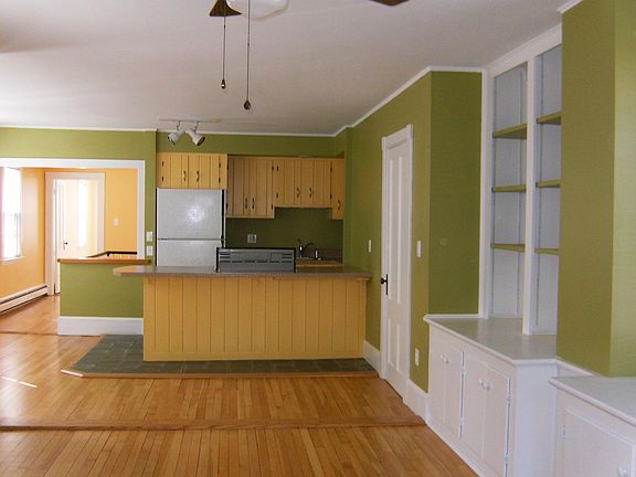 Open concept living room to kitchen. Kitchen stove replaced with flush to counter top gas stove insert with oven.