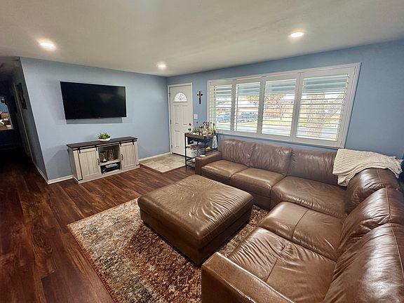 Living room with plantation shutters looking out onto front lawn