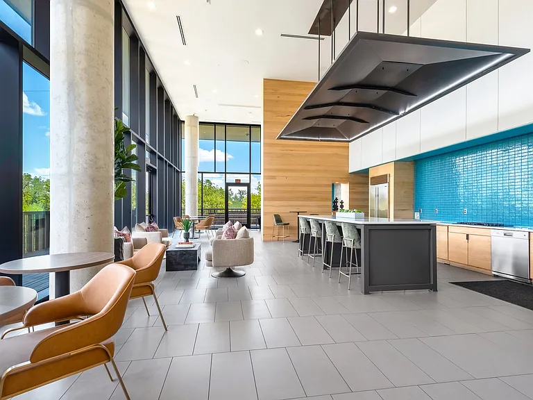 Resident Lounge with Floor-to-Ceiling Windows, Kitchen Area, and Cozy Seating