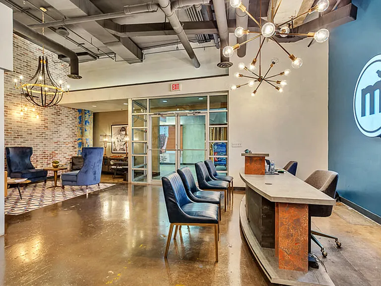 leasing office with concrete floor, and brick wall