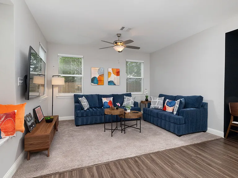 Spacious open living room with two comfy couches and a large flat-screen TV_perfect for relaxing nights in or movie marathons.