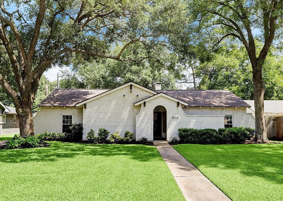 Exterior faÃ§ade with mature trees and lush landscaping