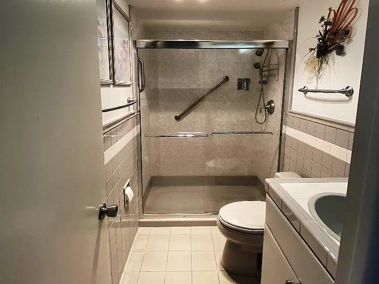 Guest bathroom. Walk-in shower with Kohler safe surface, glass sliding doors, comfort height toilet and vanith counterm heat lamp.