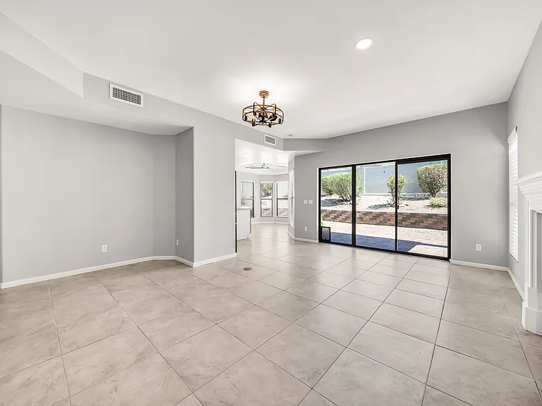 Family room with triple sliding glass doors and opening into the kitchen from here.