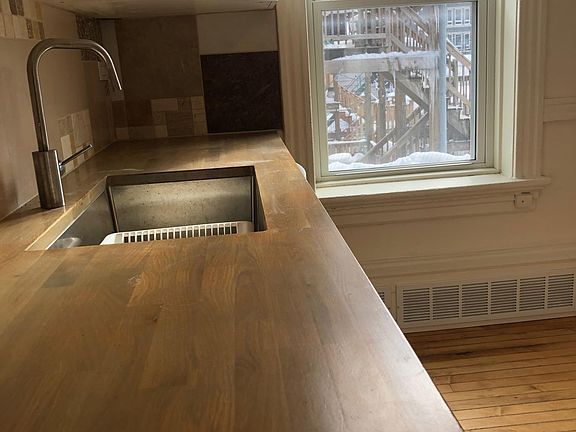 Wood block counter top with custom tile backsplash. Deep stainless undermount sink, and new dishwasher.