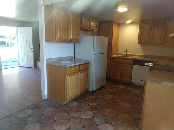 kitchen and living room downstairs back door to communal yard. On right is sliding glass door into parking lot