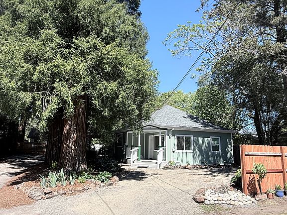 Front of house with driveway on the left and parking in front behind the fence