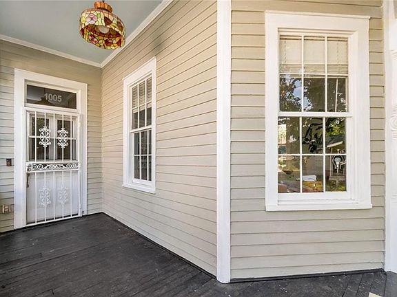 Inviting front porch with a dark-finished wood floor and light-toned siding
