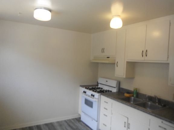 Kitchen area with new paint, flooring, and countertop.