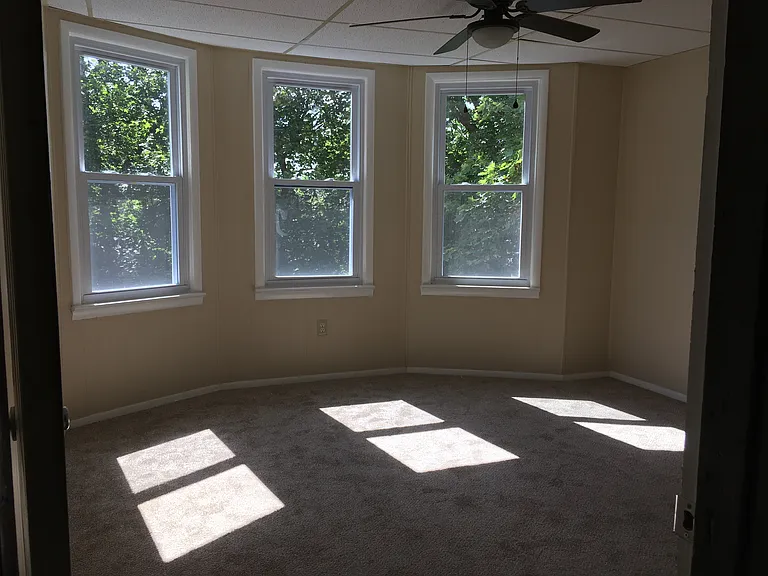 Middle bedroom facing yard. It has 3 windows and ceiling fan.