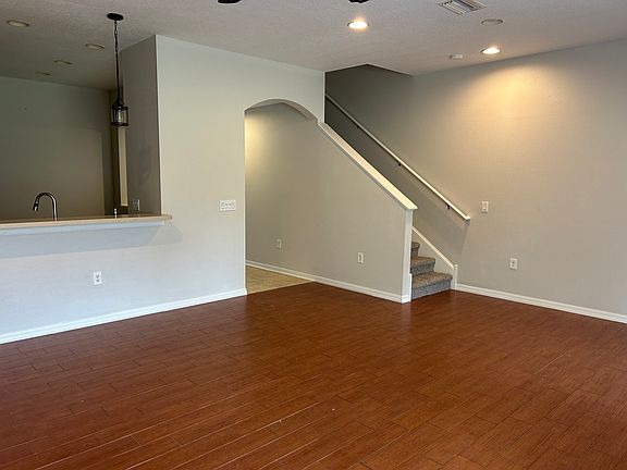 Living room that opens to kitchen with solid surface floors