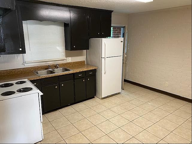 Kitchen with tile floor, new refrigerator, new stove and washer hookup