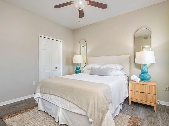 Immerse yourself in the plush serenity of our roomy guest bedroom, where wood-style flooring and a whimsical ceiling fan is everything you desire. Indulge in the comforts of this delightful retreat.