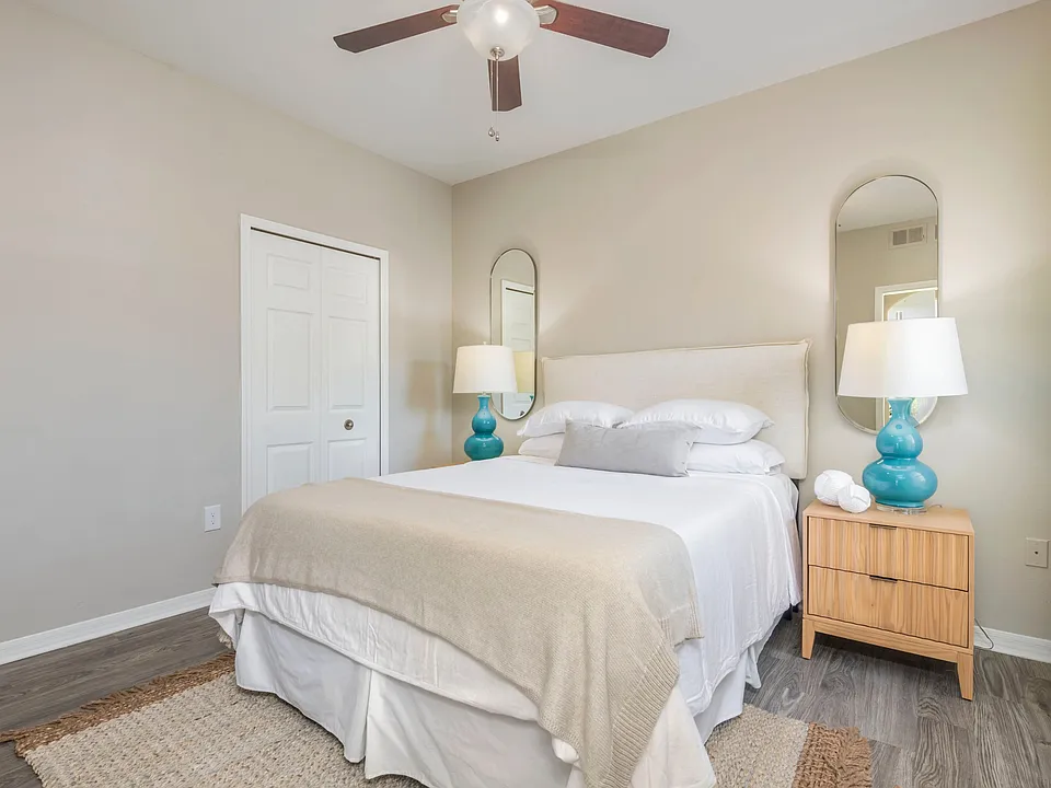 Immerse yourself in the plush serenity of our roomy guest bedroom, where wood-style flooring and a whimsical ceiling fan is everything you desire. Indulge in the comforts of this delightful retreat.