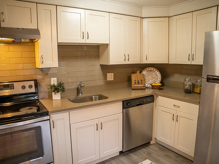 Modern kitchen with stainless steel appliances, elegant cabinetry, and warm lighting creating a cozy atmosphere.