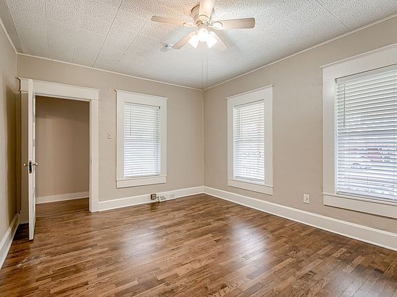 Primary bedroom with ceiling fan, wood floors and lots of light!