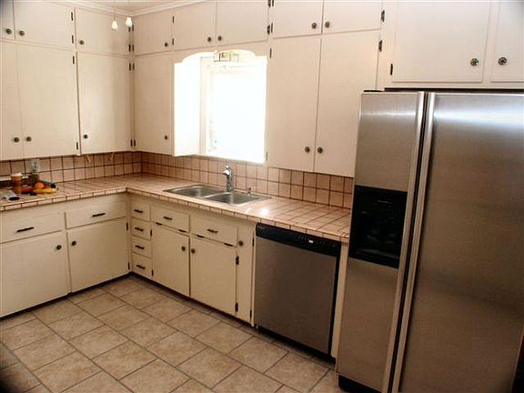 Kitchen, view 2 with stainless dishwasher and refrigerator. Nice tile countertop and floor. Lots of cabinets.