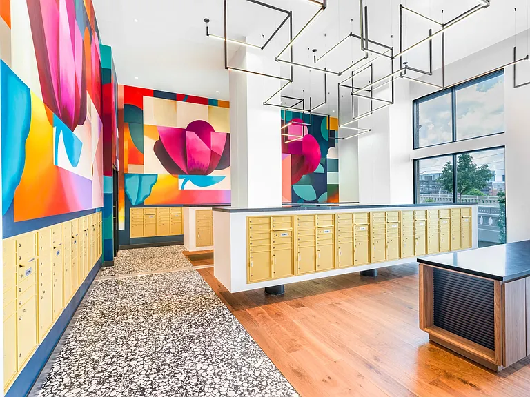 Colorful wall murals and bold geometric lighting elevate the mailroom with modern Nashville flair.