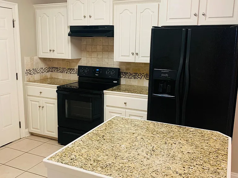 Island with granite tile top though out the kitchen