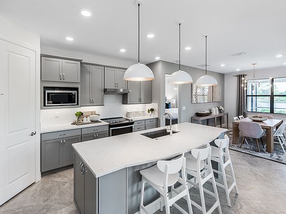 Bright kitchen with 42 wood cabinets and stainless steel appliances, open to cafe