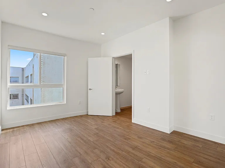Bedroom with Large-Size Windows, Vinyl Flooring, Recessed Lighting, and Bathroom