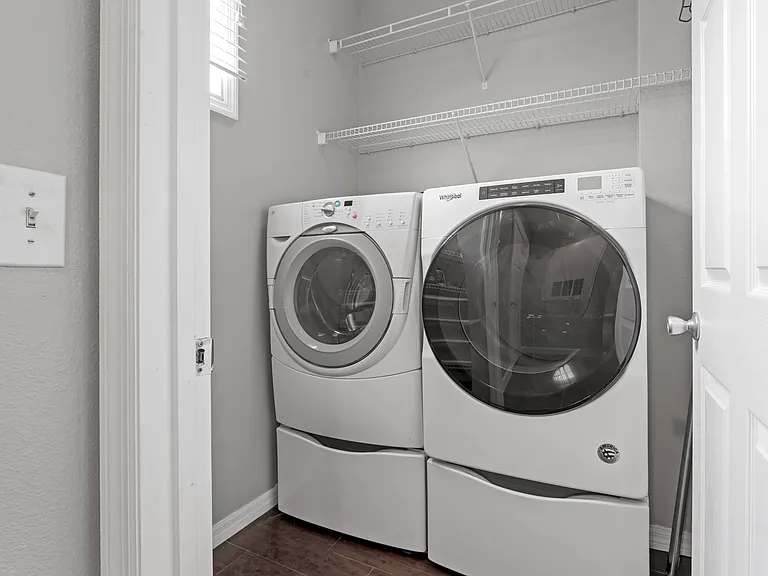 Laundry room with high efficiency washer and dryer and storage pedestals