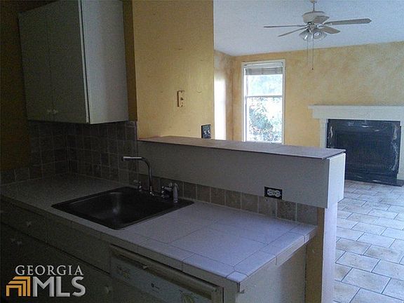 Kitchen breakfast bar looking into vaulted ceilings and fireplace