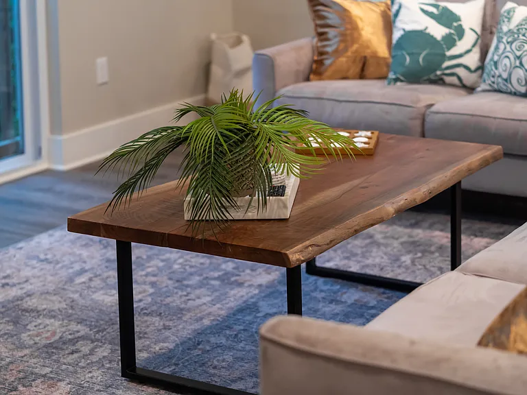 Thoughtfully styled with warm live-edge wood tones, chic coastal accents, and crisp white cabinetry for a luxury coastal-modern vibe
