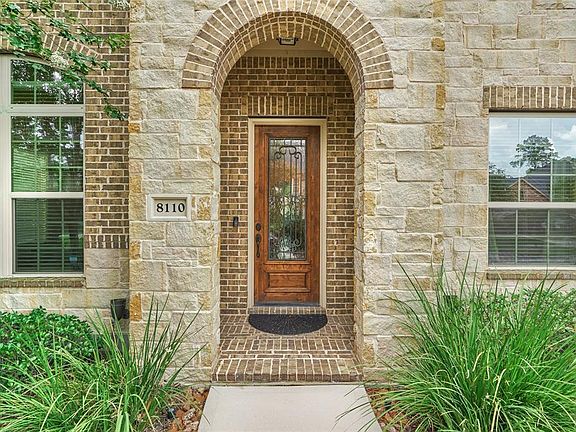 The covered entry has a wood door with wrought iron and glass.
