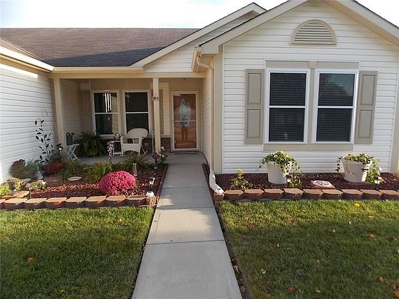 View of darling 14 X 6 covered front porch with sidewalk to street.  Gorgeous landscaping. Total electric home. Monthly budget $163.