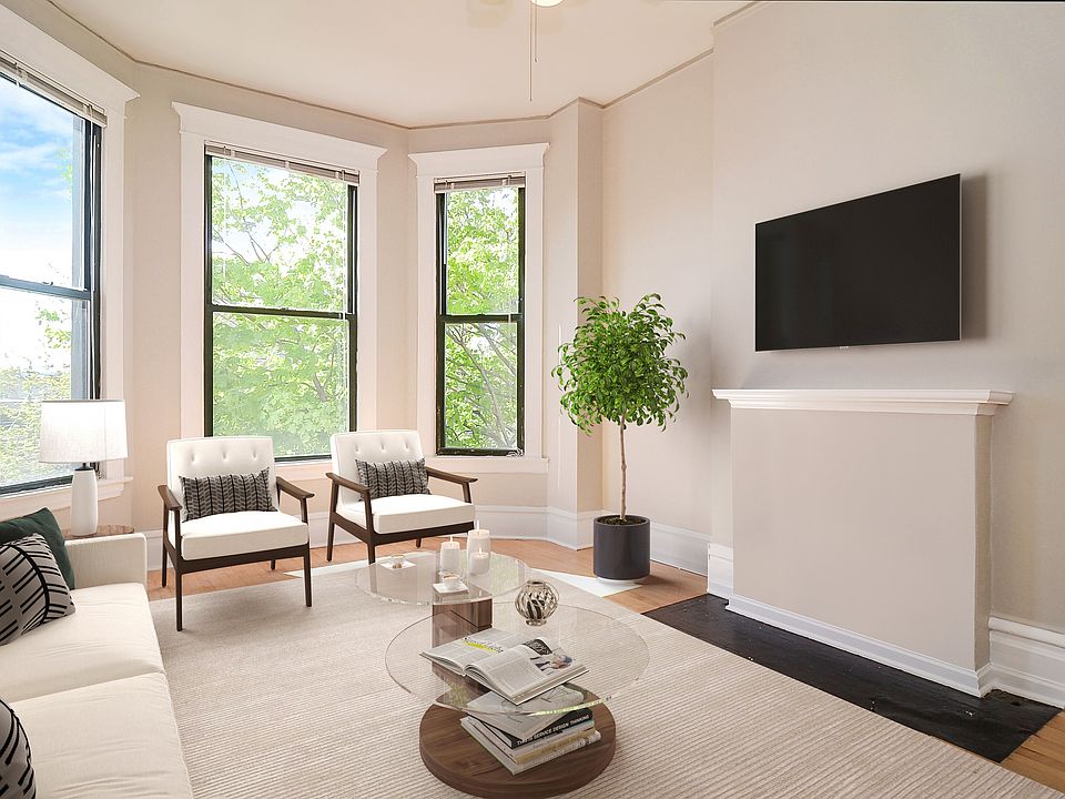 Living room with high ceilings, great natural light with bay windows and faux fireplace.