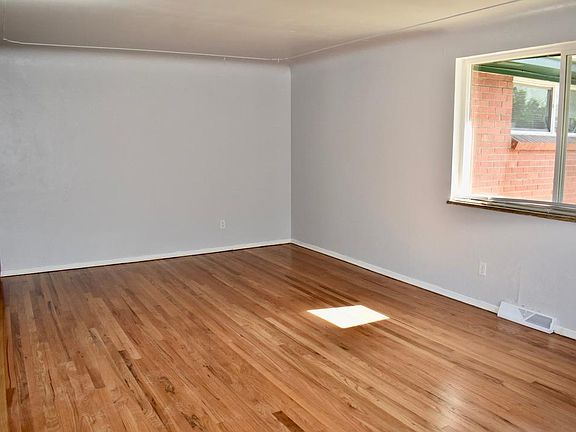 Spacious and inviting living room with new paint and original hardwood floors