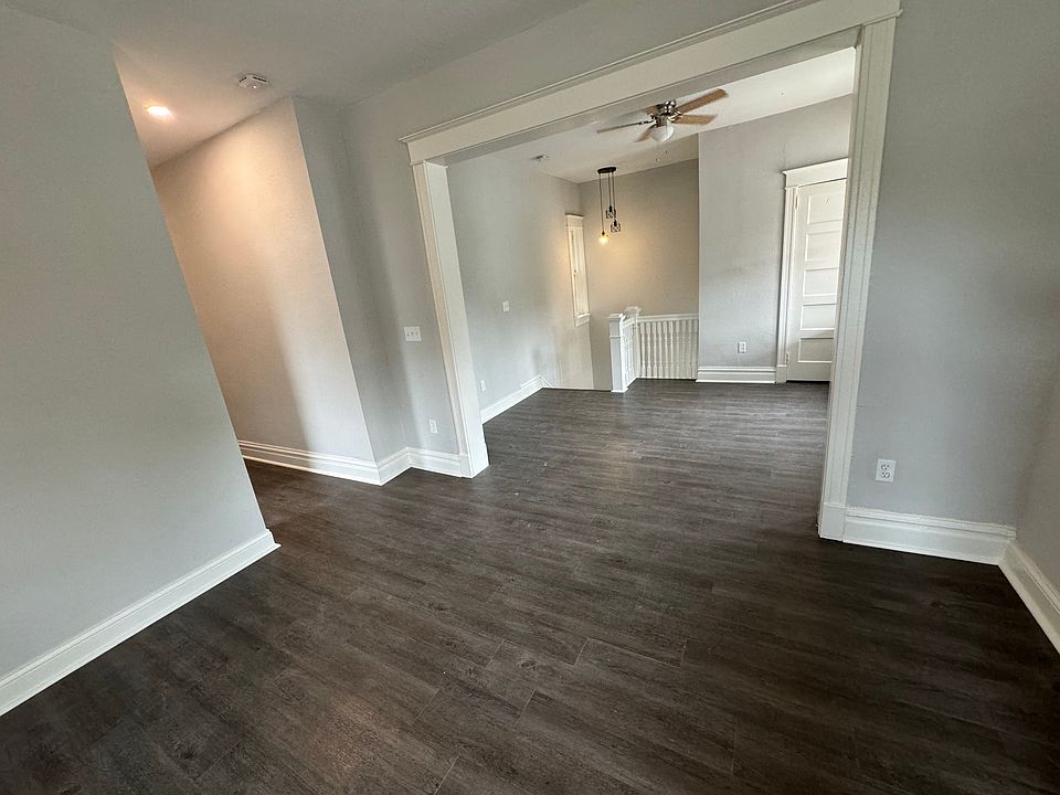 Semi-divided living room with ceiling fans, natural light and coat closet