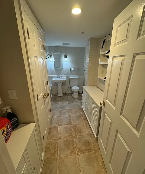 Laundry in doors to left: stackable LG smart washer/dryer. Two white cabinets delivered with property.