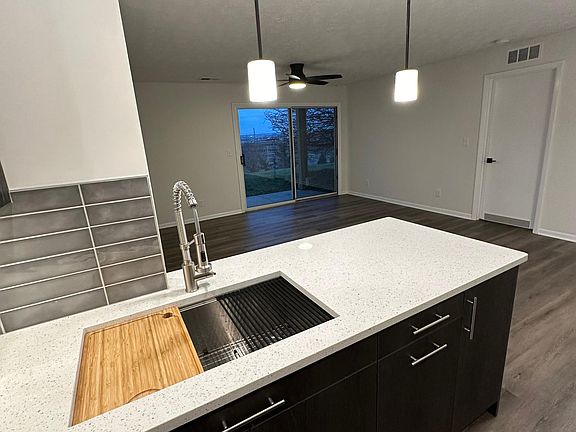 Kitchen looking into laundry. Pro-style sink with integrated cutting board and drying mat.